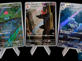 four pokemon cards are displayed in a row on a black background