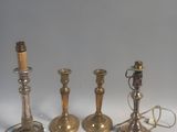 quatre bougies en laiton sont alignées sur une surface blanche