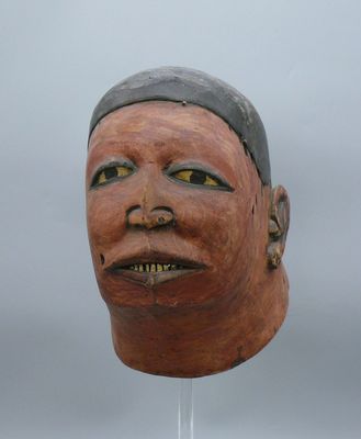une image d'un masque en bois sur un support
