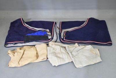 un tas de vêtements par terre, à côté d'une paire de gants