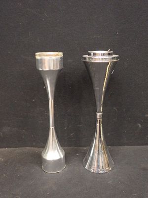 deux bougeoirs en argent posés l'un à côté de l'autre sur une table