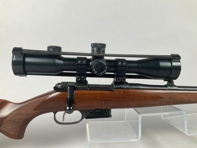 a rifle with a scope mounted on top of it