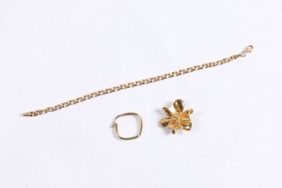 un gros plan d'un collier et d'une bague posés sur une surface blanche