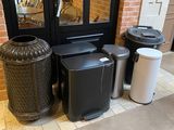 several trash cans are lined up in front of a door