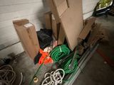 a pile of boxes and hoses in a garage