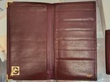 a brown leather wallet and a wallet case sitting on a table