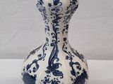 un vase bleu et blanc posé sur une table blanche