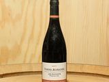 une bouteille de vin posée sur un tonneau