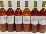 six bottles of wine are lined up in a row on a table