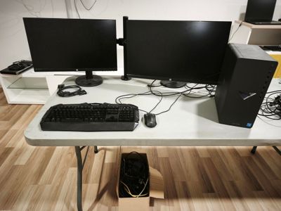 two computer monitors and a keyboard on a desk