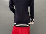 a mannequin wearing a red pleaed skirt and black sweater