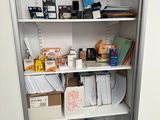 un placard rempli d'objets et un ordinateur portable posé par terre