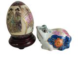 an egg and a frog figurine sitting next to each other
