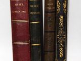 plusieurs vieux livres sont alignés sur une surface blanche