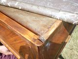 une personne allongée par terre, sous un banc en bois
