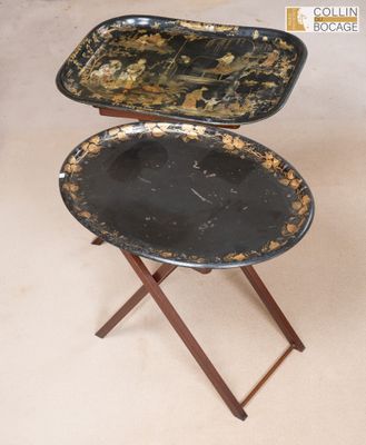 une paire de plateaux noirs et dorés posés sur un support en bois
