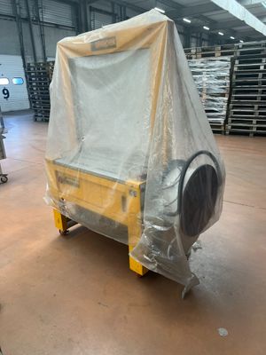 un canapé recouvert d'une bâche en plastique dans un entrepôt
