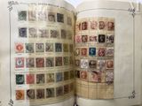 an open book with stamps on it on a table