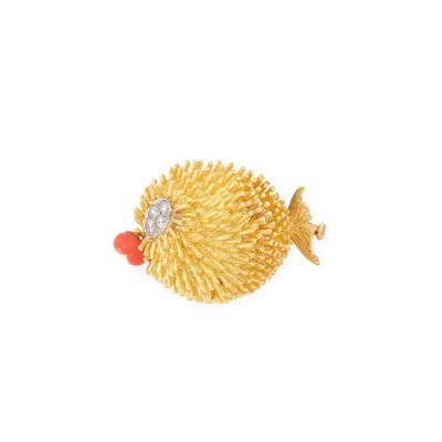 un gros plan sur une broche en forme de poisson rouge avec un diamant dans la bouche
