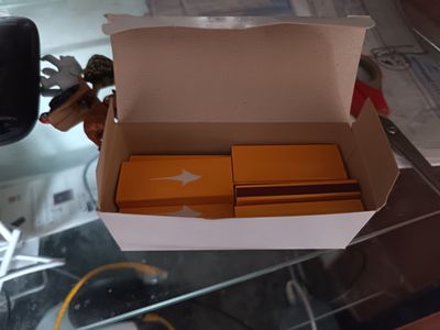 une boîte remplie de boîtes orange posée sur une table en verre