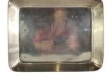 a reflection of a woman in a mirror on a silver plate