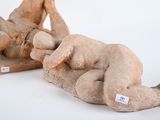 a statue of a naked man laying on the ground next to another statue of a naked man
