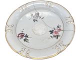 a white plate with flowers on it on a white surface