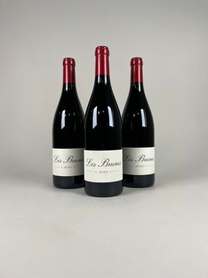three bottles of red wine sitting on top of a table