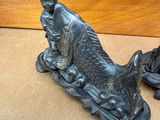 deux figurines représentant un homme et un poisson posées sur une table