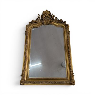 un miroir encadré d'or sur un mur blanc avec un fond blanc