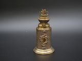 une clochette en or surmontée d'une couronne