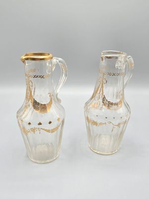 pair of clear glass vases with gold rims on a white surface