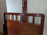 a wooden bed with a wooden headboard and foot board