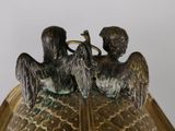 two birds sitting on top of a vase on a table