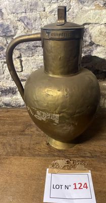 un vase en or posé sur une table en bois, avec une étiquette