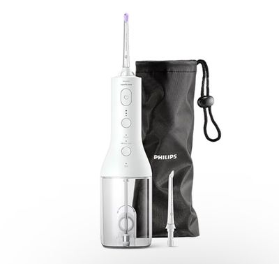 une brosse à dents électrique blanche à côté d'un sac noir
