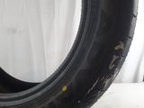 a close up of a tire on a white surface with a white curtain in the background