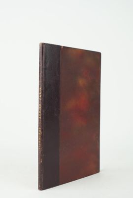 un vieux livre posé sur une table blanche à côté d'un mur blanc