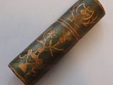a green and gold case with a flower design on it