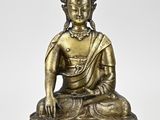 a bronze figure of a buddha sitting on a lotus