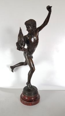 bronze statue of a boy holding a bird on a wooden base