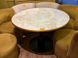 une table ronde entourée de chaises dans une pièce