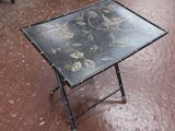 une table noire ornée d'un motif floral