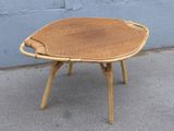 une petite table en bois avec une assise tressée