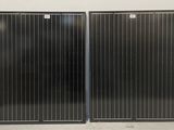 une paire de panneaux solaires noirs sur un mur blanc dans une pièce