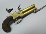 un vieux pistolet avec une poignée en bois sur une surface blanche