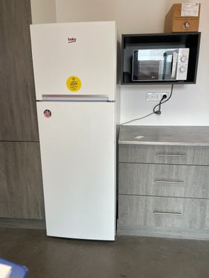 un réfrigérateur blanc et un micro-ondes dans une petite cuisine