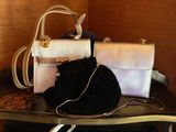 two purses sitting on a table next to each other