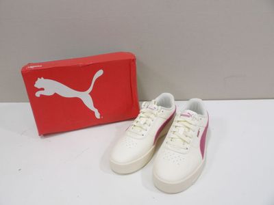 white and pink puma sneakers with box on a table