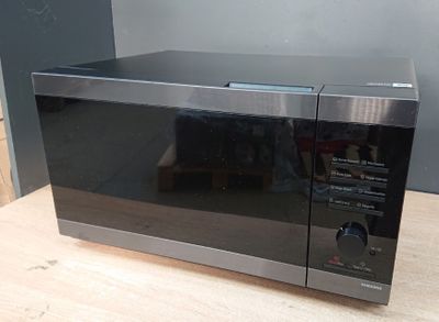 a black microwave oven sitting on a wooden table